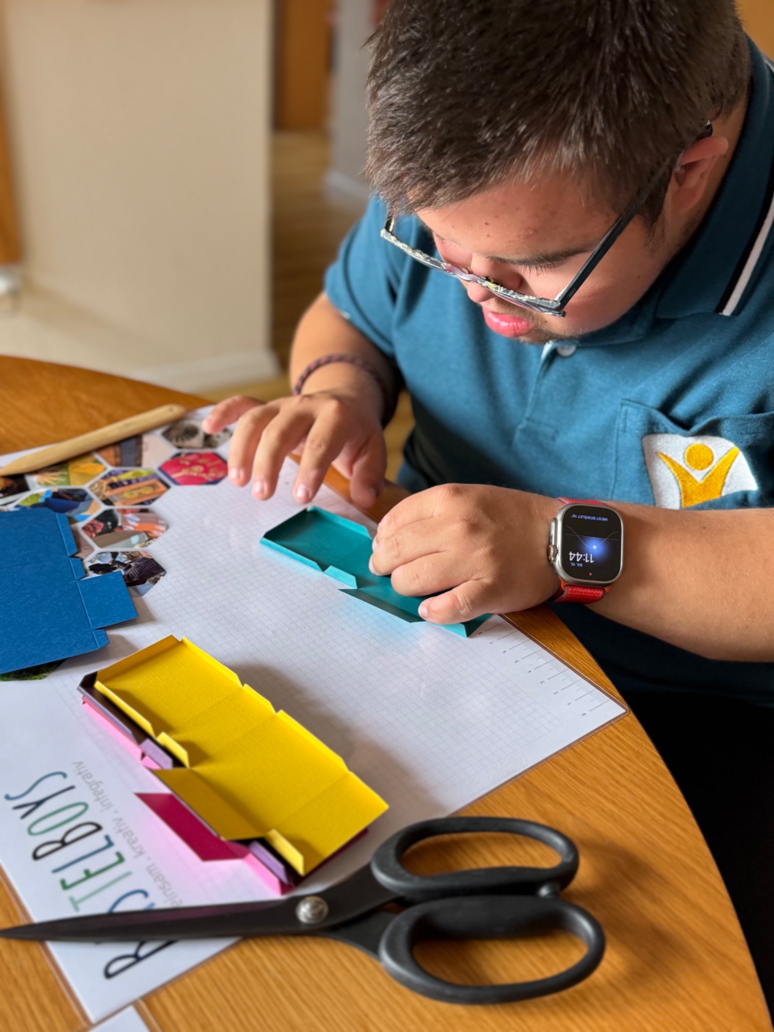 Simon beim Gestalten mit Papier